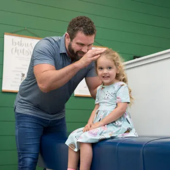 Dr. Josh Hasty providing chiropractic adjustment to a child in Suwanee, GA.