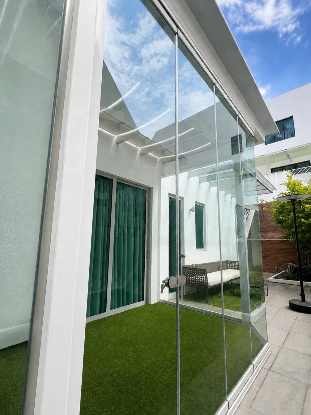 Glass roof installed above a narrow outdoor courtyard, bringing in natural light while providing sheltered use of the space.