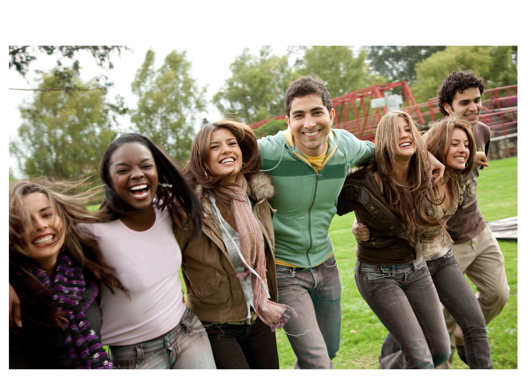 A train passes by a fence on a sunny day.