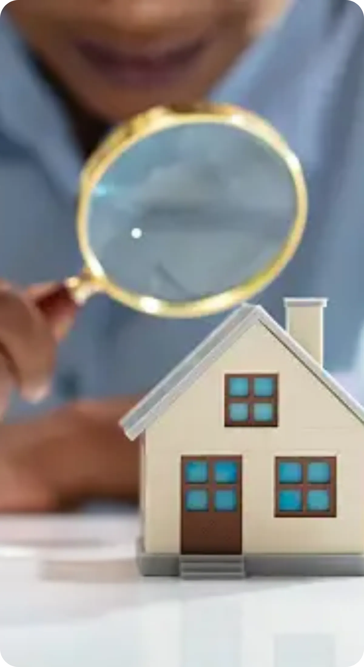 Home inspector in Charlotte, NC examining house model with magnifying glass | Charlotte Home Inspector Pros