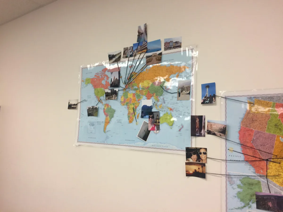 World Map on a wall with string to places and pictures