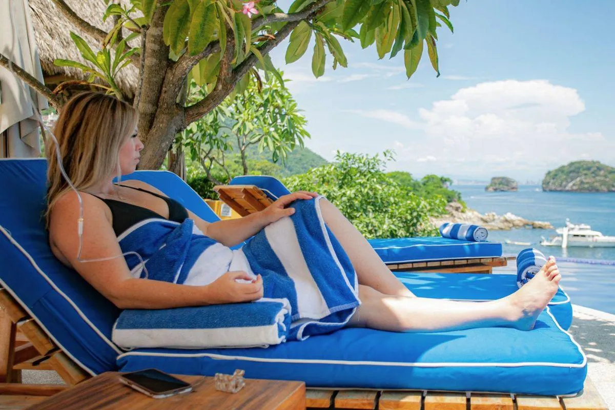 Woman getting an IV while enjoying the ocean in Puerto Vallarta