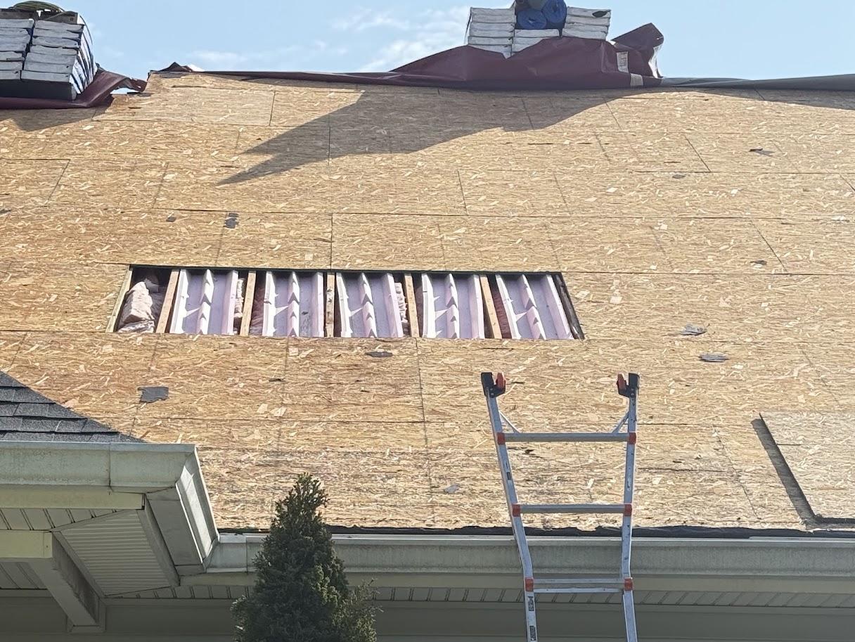 View of a dormer window and surrounding new roof shingles.