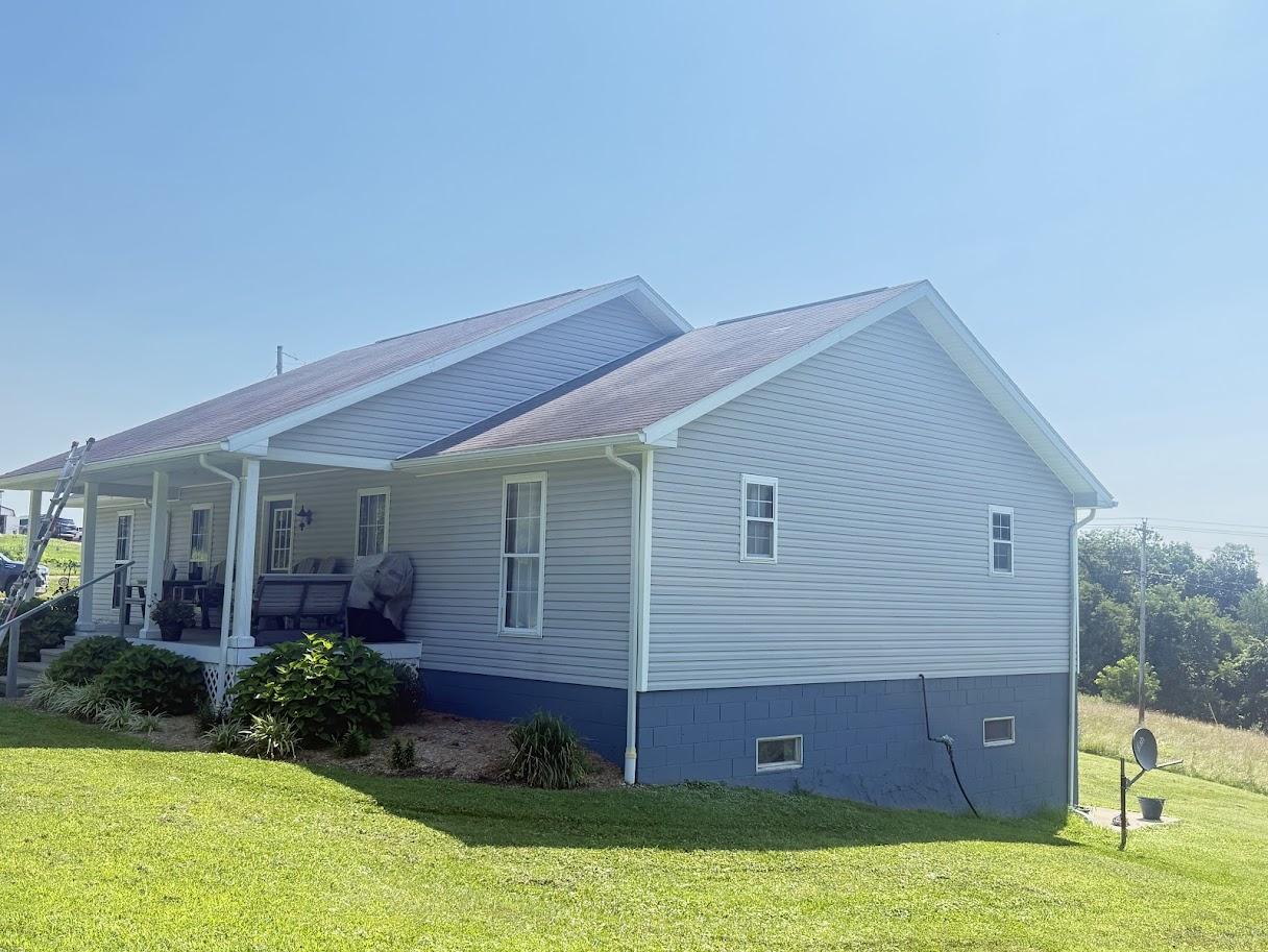 Close-up of a roof ridge with dark gray shingles.