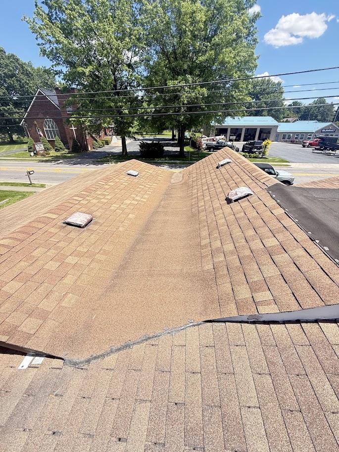 Before image of the house with an older, lighter gray/brown roof showing signs of wear.