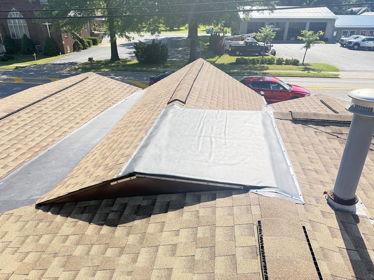 Close-up of a roof valley with dark gray shingles.