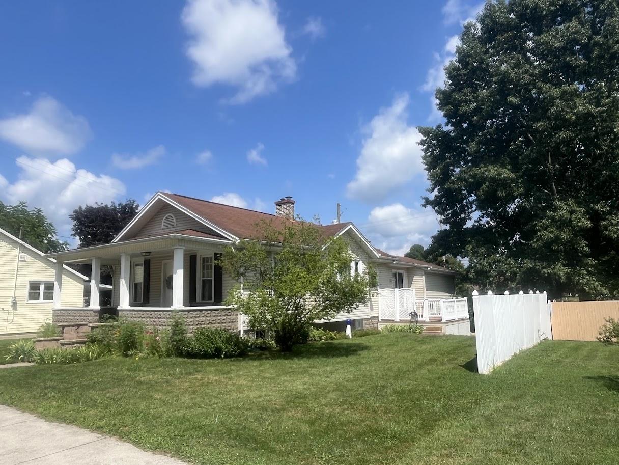 Before image of the house with an older, lighter gray/brown roof showing signs of wear.