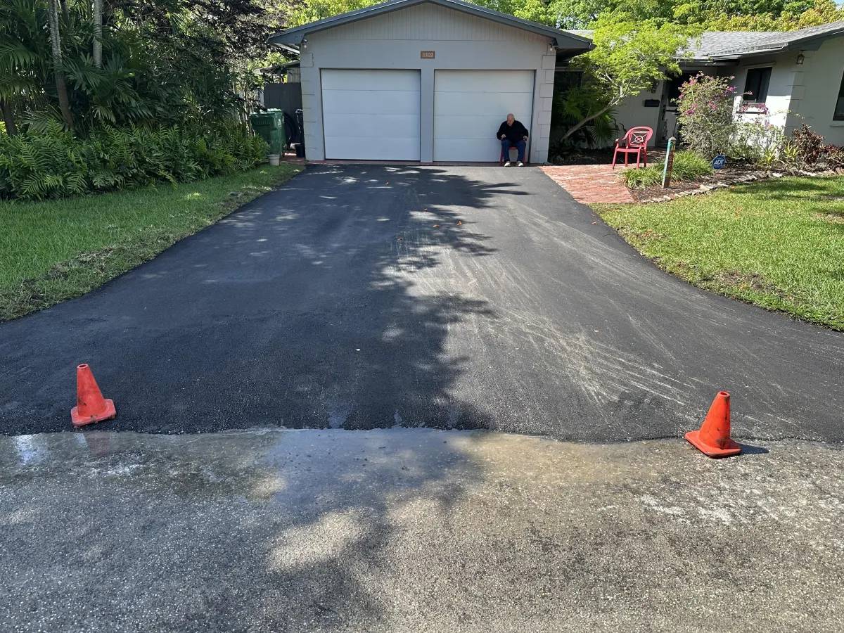 Expert team performing asphalt resurfacing on a Miami driveway, applying a new asphalt layer to restore the surface and enhance appearance.
