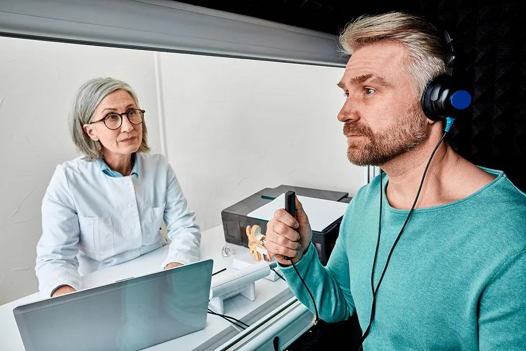 white wireless earbuds beside silver laptop