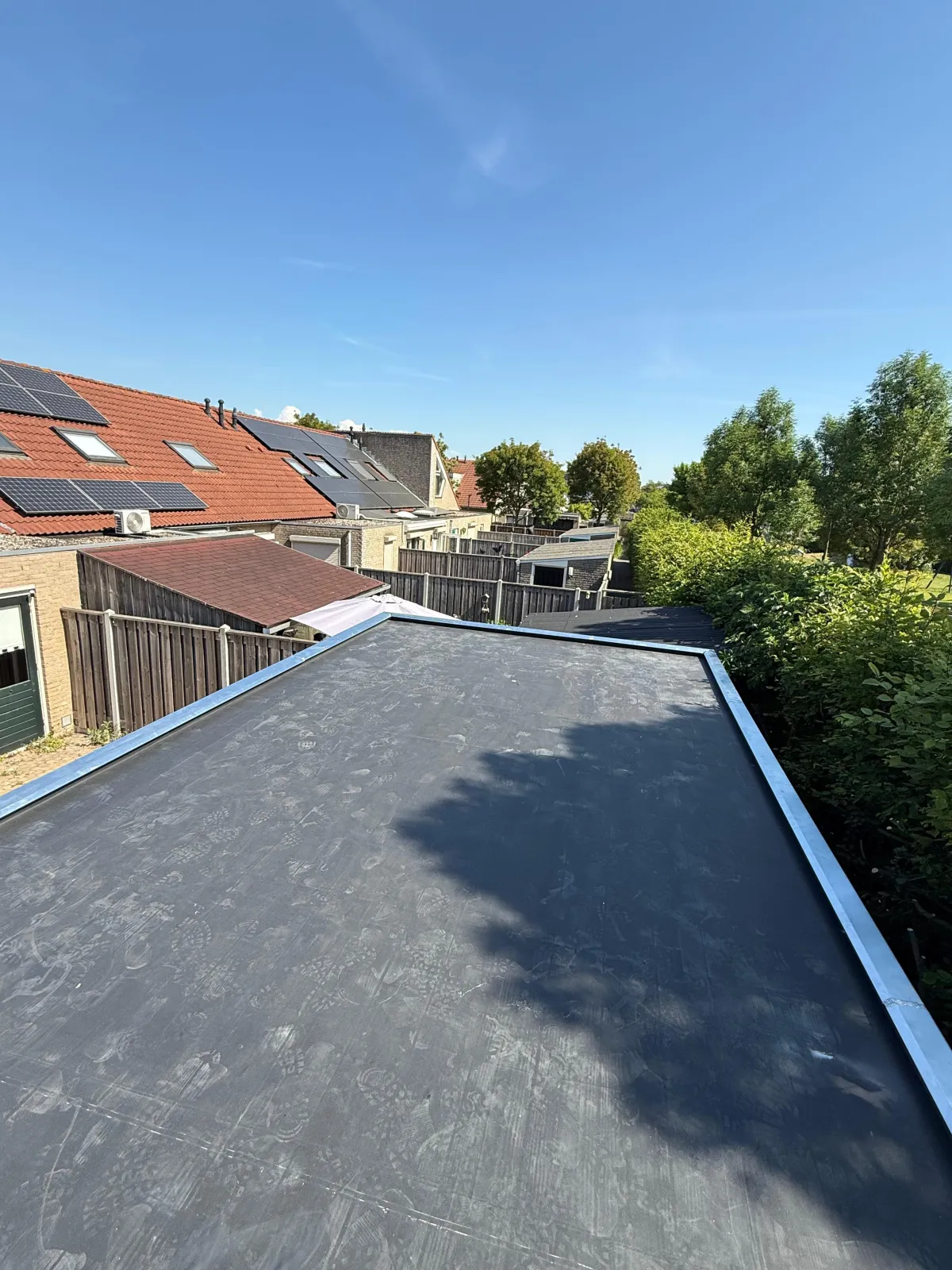 Zinken schoorsteenafwerking op een plat dak bij een woning