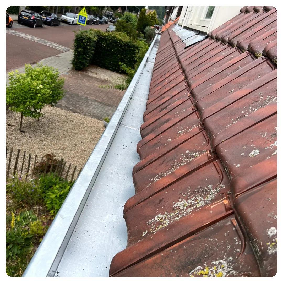 Zinken dakgoot langs een woning met sierlijke afwerking