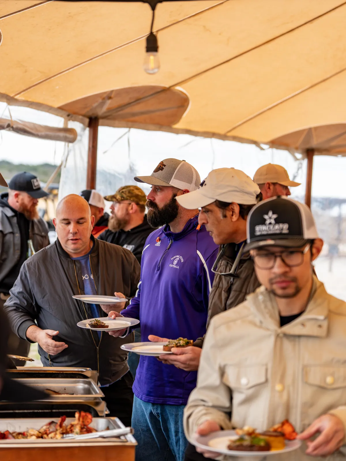 men in line at an event getting food