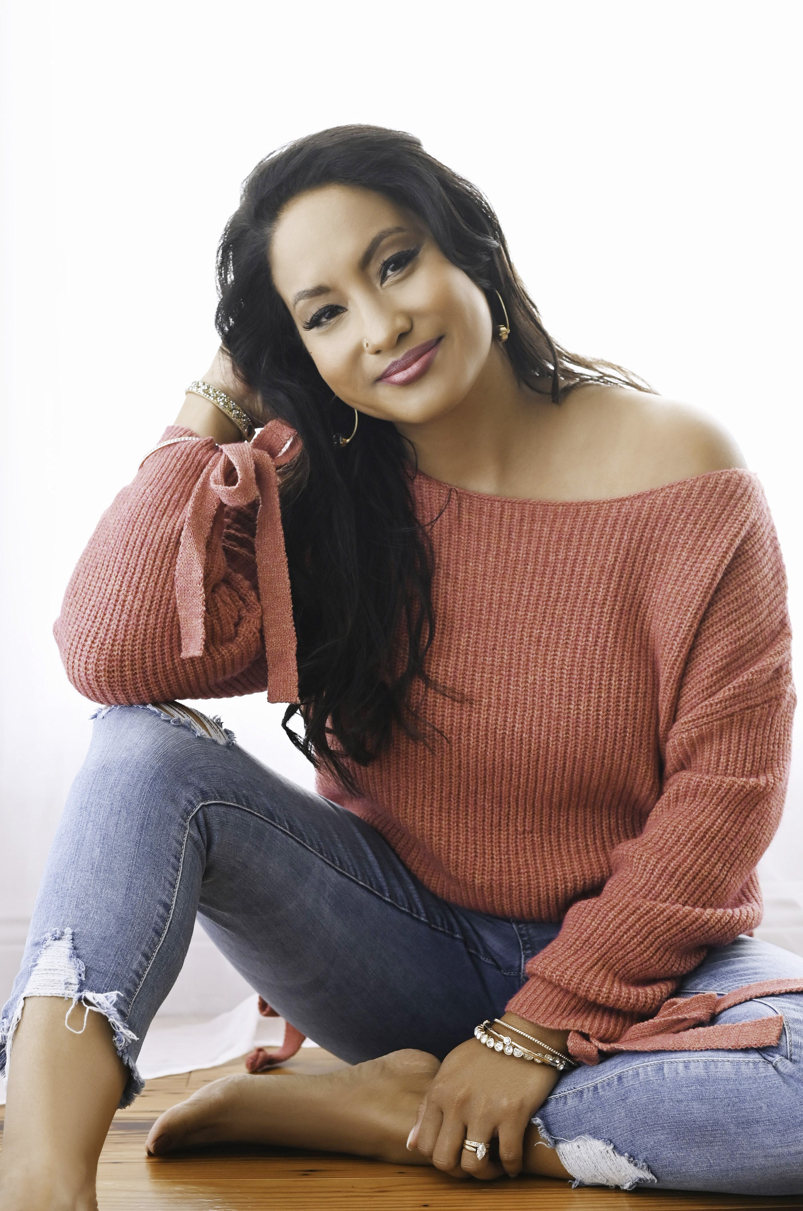 Licensed Massage Therapist Kimberly smiling and standing in her treatment room at Ready Pain Management, ready to assist clients with her professional massage therapy services.
