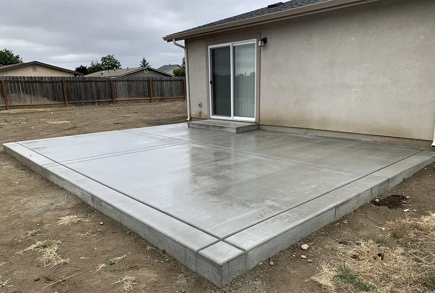 Freshly finished concrete patio attached to the back of a modest home in Red Bluff California