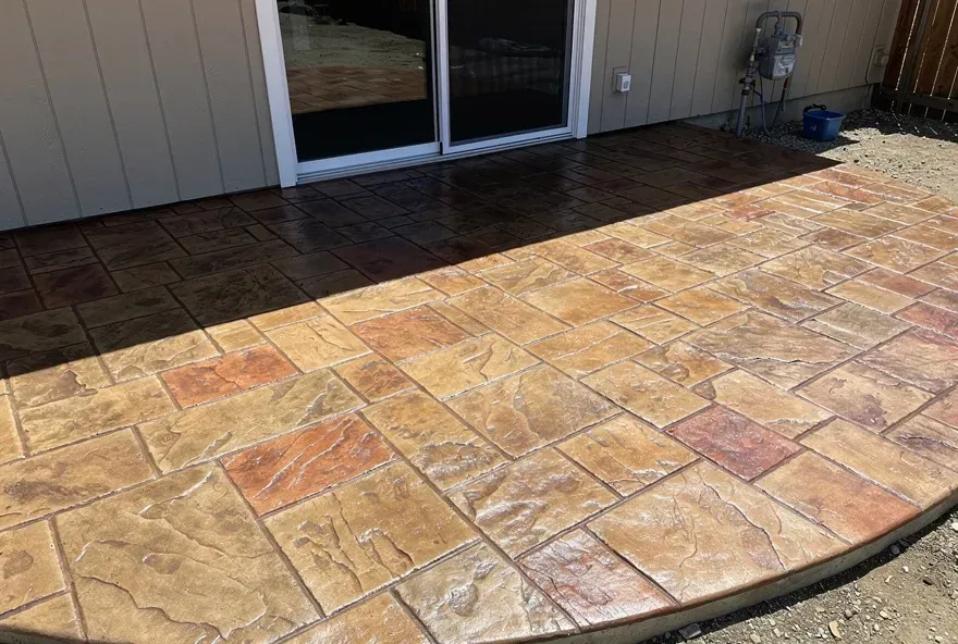 Close-up of freshly finished stamped concrete patio with stone pattern attached to home in Red Bluff California