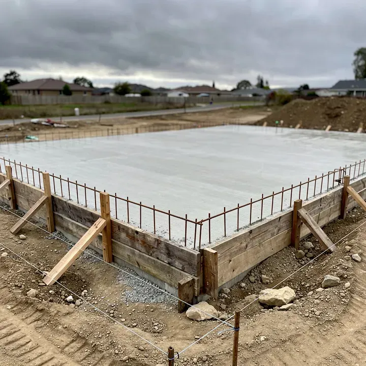 Freshly poured concrete foundation with rebar and wood forms at a residential construction site in Red Bluff California