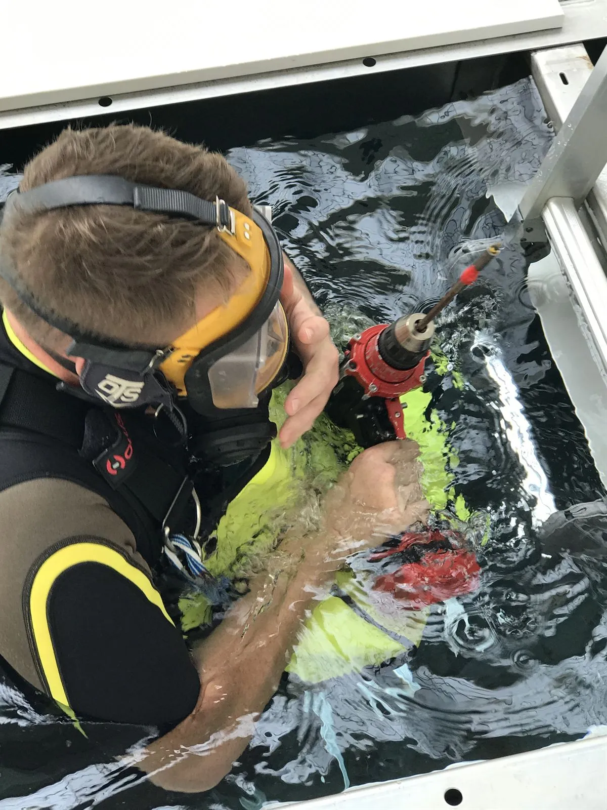 Access Underwater diver carrying out maintenance in a commercial swimming pool