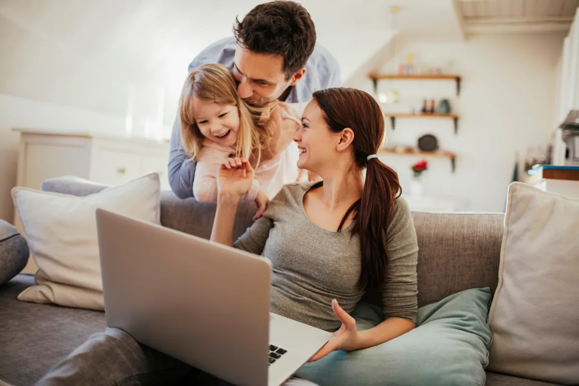 family on couch browsing house cleaning services online