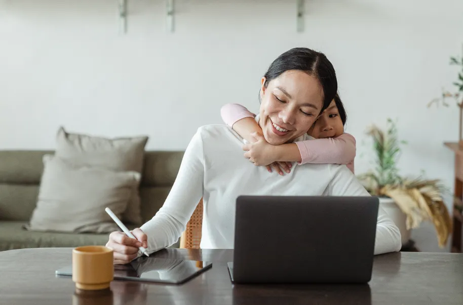 mother scheduling house cleaning services while child hugs her