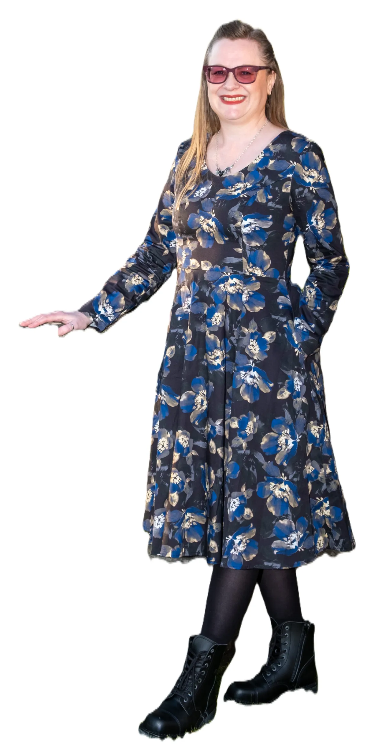 Leah standing wearing a black dress with blue flowers on it