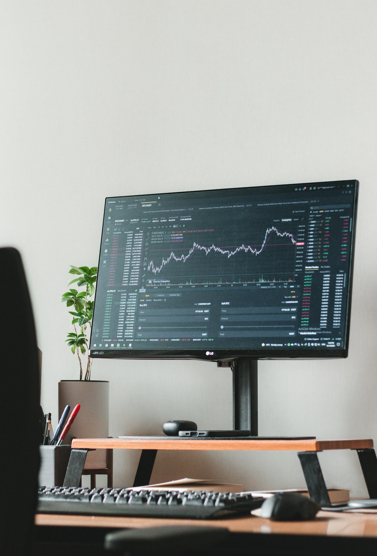 Trading terminal screen showing a candlestick chart alongside a live order book and market trades table with buy and sell prices