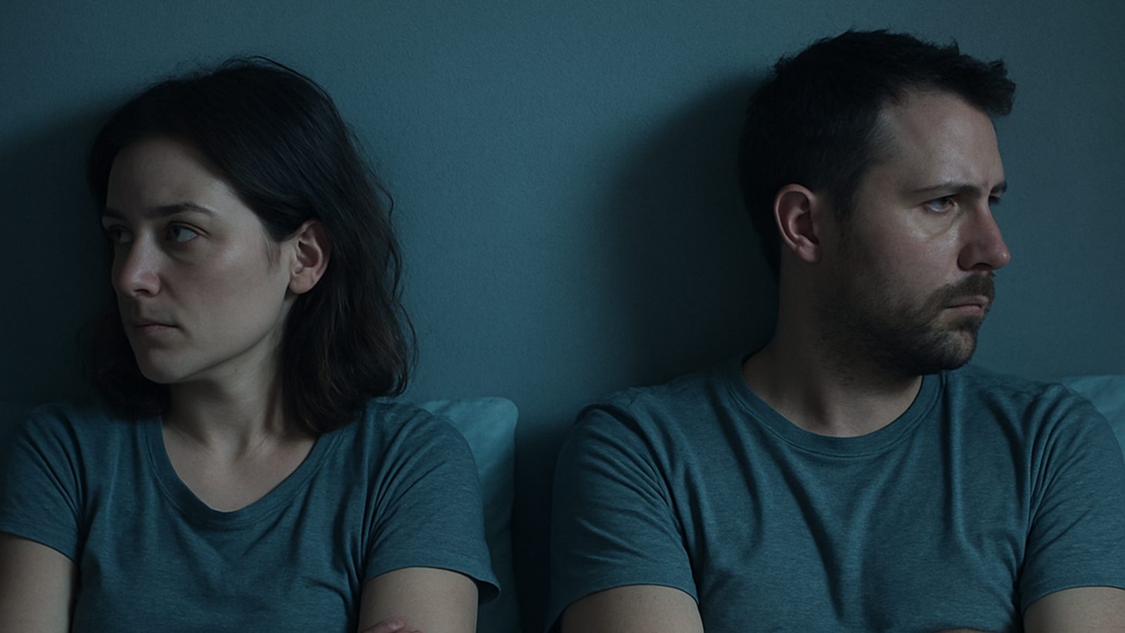 Pareja en la cama de espaldas, cada uno mirando hacia un lado, sin contacto