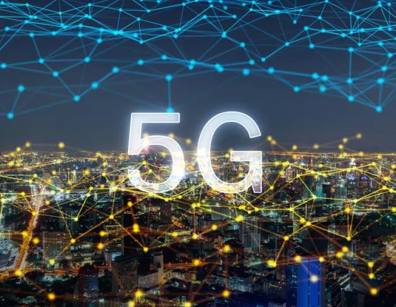 5G label over the view of a large nighttime suburban neighborhood with lines connecting point of light overlaying the buildings and sky