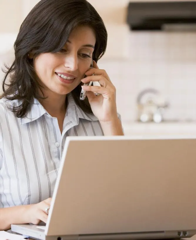 Professional woman on a laptop & talking on a cell phone