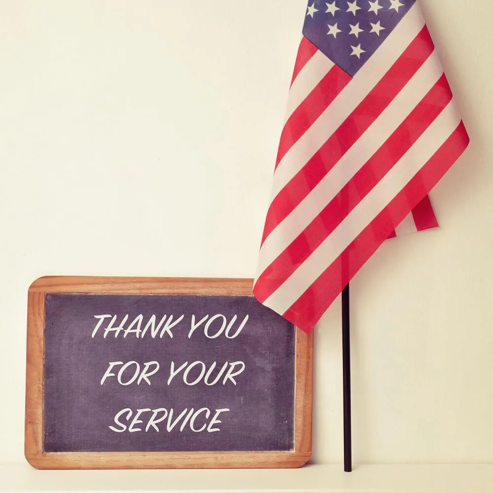 US flag with a board saying thank you for your service