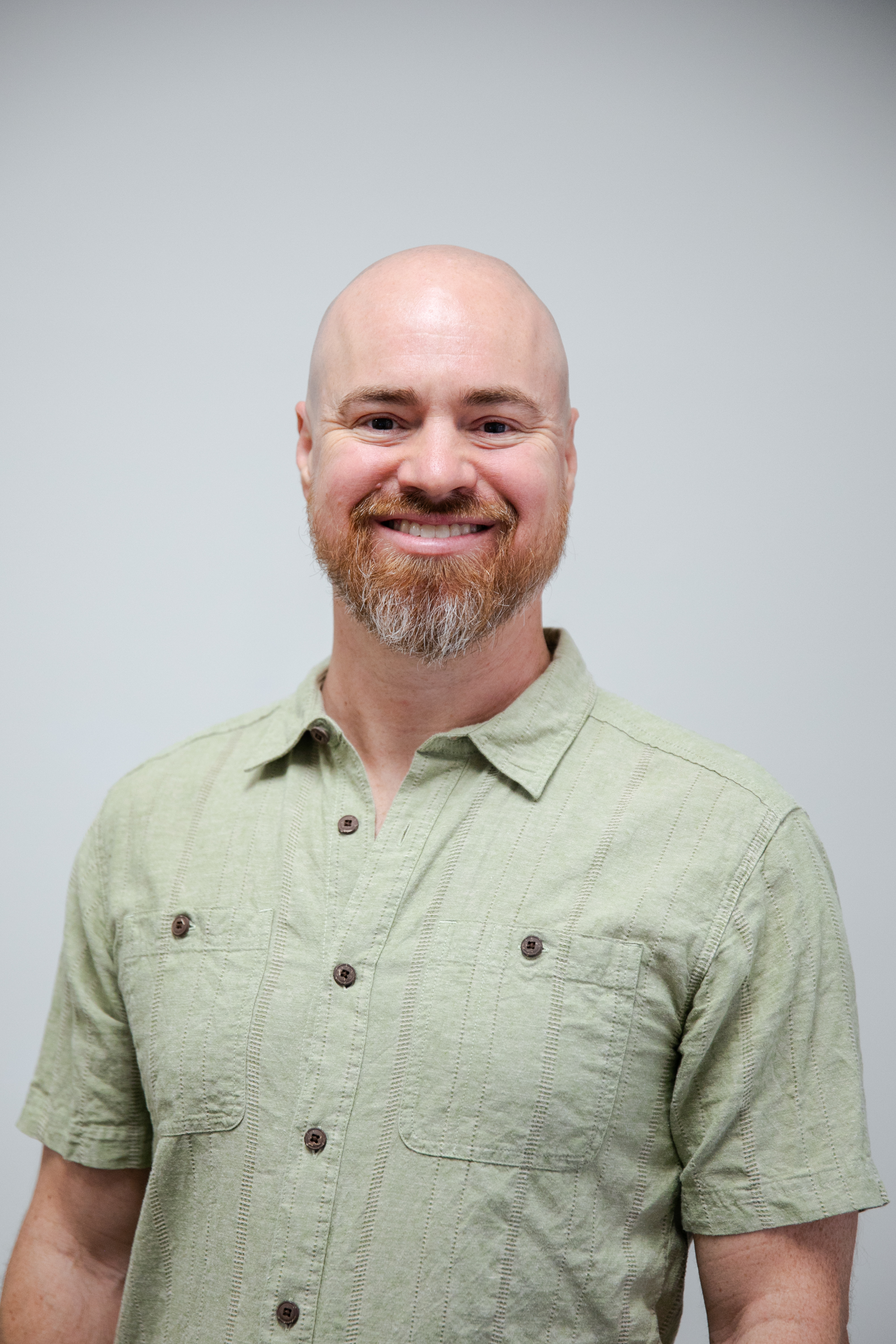Man exercising on a leg press machine with a female trainer assisting, demonstrating personalized exercise therapy at ZOVA Chiropractic Rehab Center.