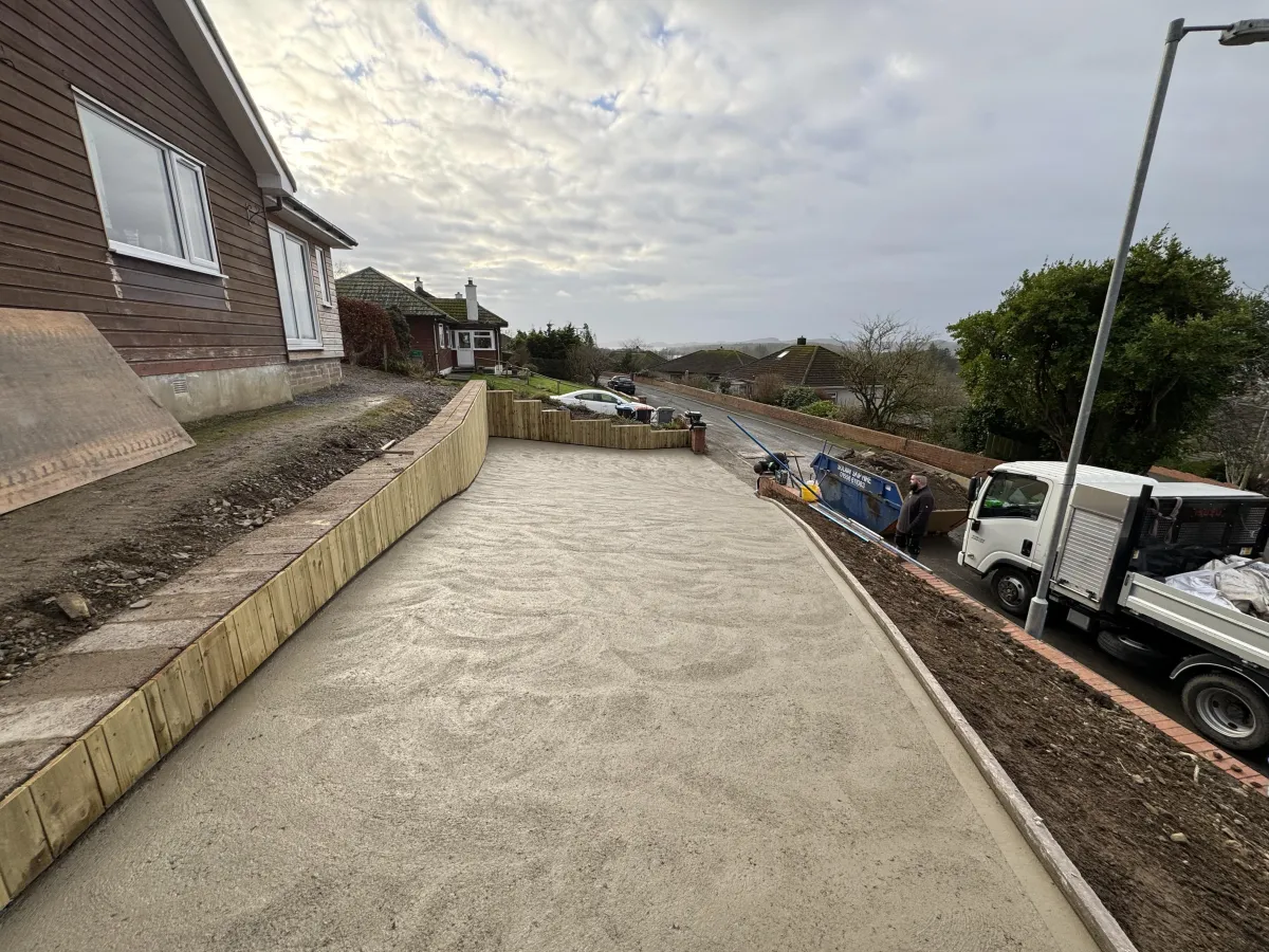 Prepared concrete driveway area with retaining timber edges after groundwork support by JF Groundworks