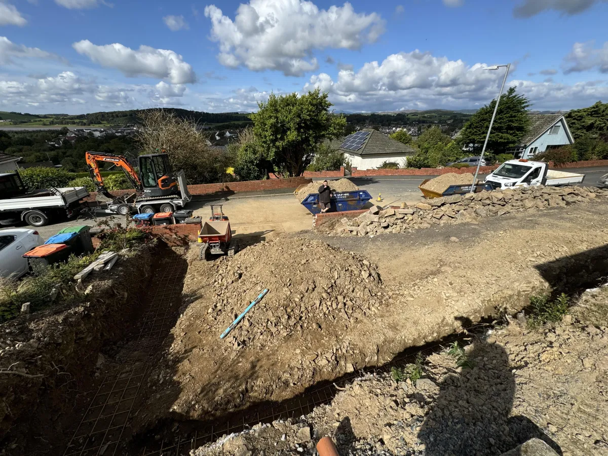 Concrete driveway and foundation preparation works showing excavated ground, site levels and material handling