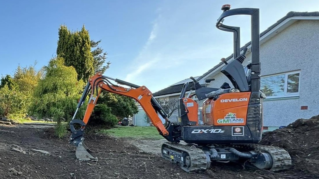 JF Groundworks Develon DX10z compact excavator working in a tight-access garden site for precise excavation and drainage work
