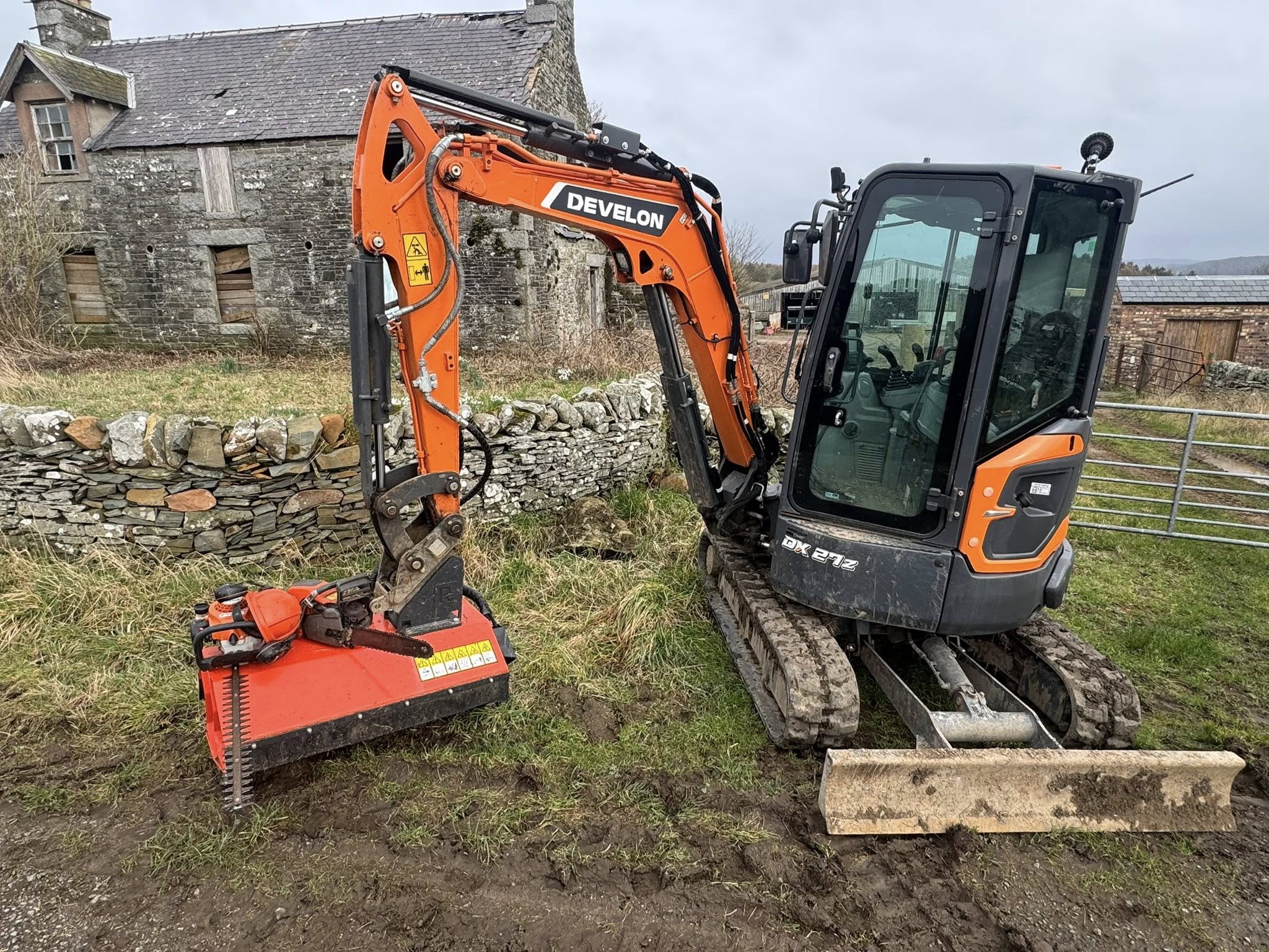 Develon DX27z excavator with flail attachment used by JF Groundworks for roadside clearance and overgrowth removal in Dumfries and Galloway