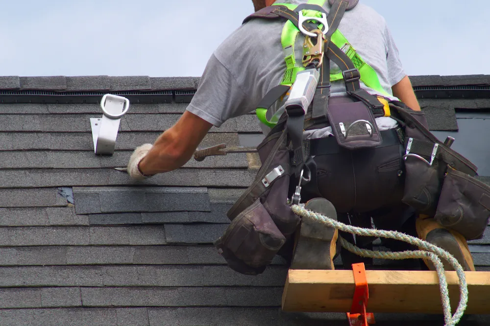 Roof repair technician fixing damaged shingles