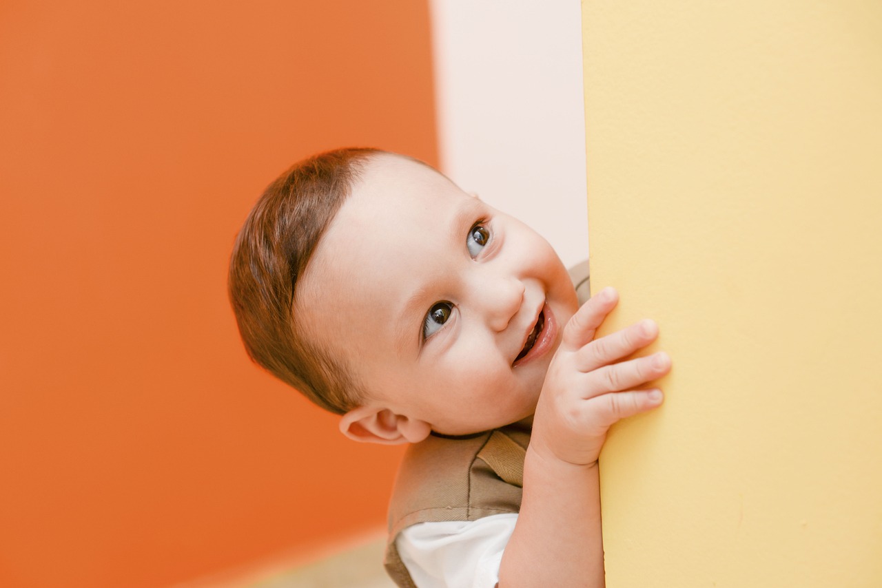 Child peeking around the corner of a wall