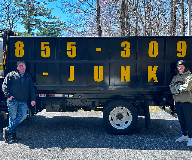 Let's Junk-It team posing beside their dump truck with phone number 855-309-JUNK