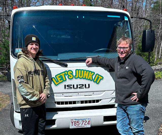 Let's Junk-It two-person team standing in front of their branded Isuzu junk removal truck