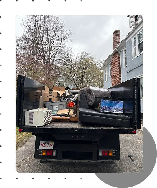 Truck bed filled with furniture, appliances, and household items after a residential junk removal job