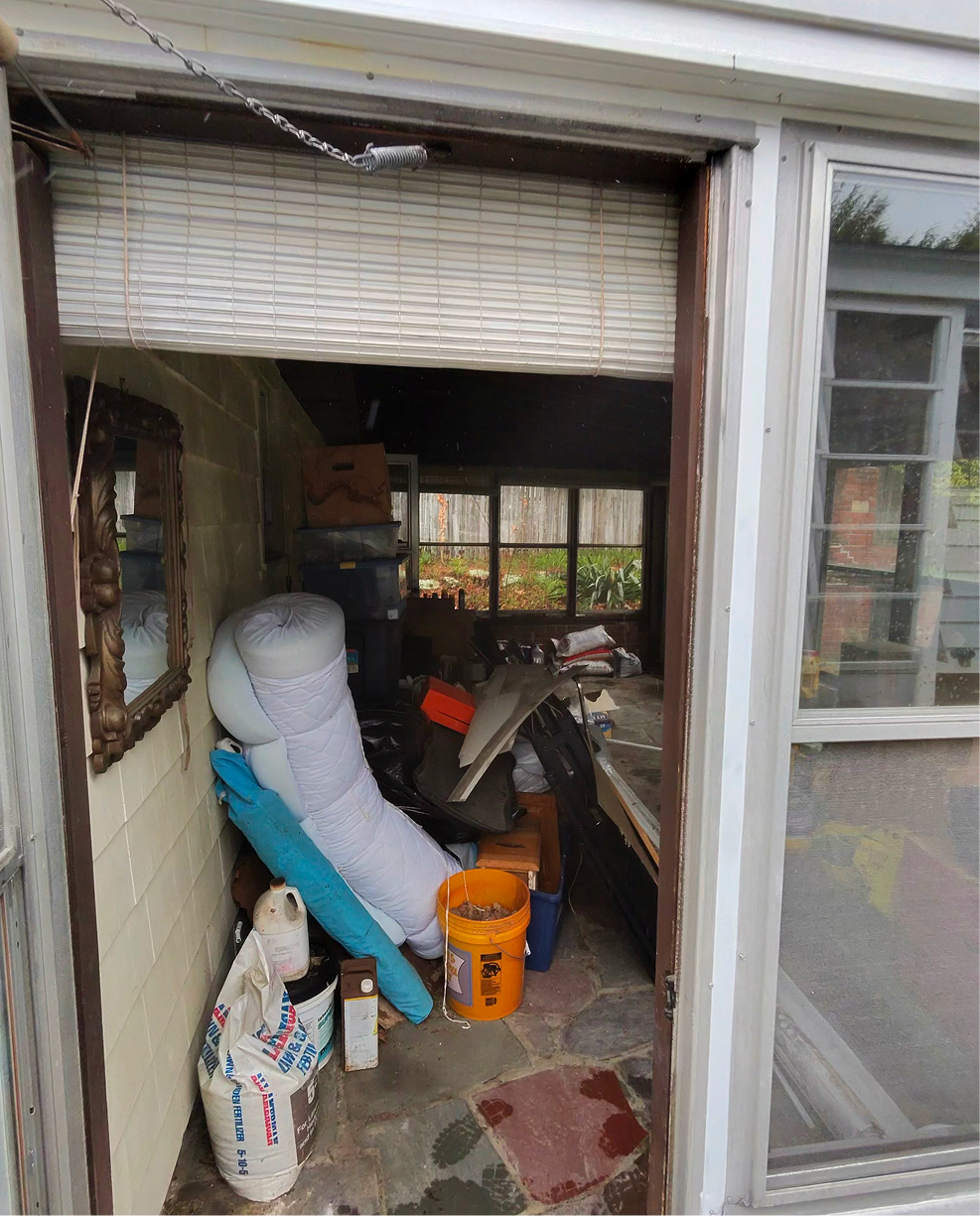 Cluttered sunroom packed with bags, supplies, and debris before a professional junk removal and cleanout service