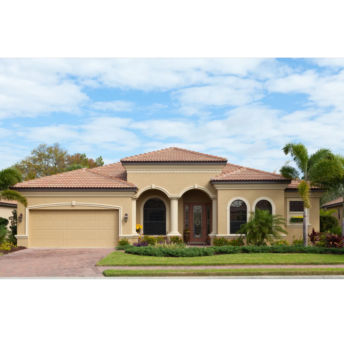 house with brown stucco, red roof, and palm tree