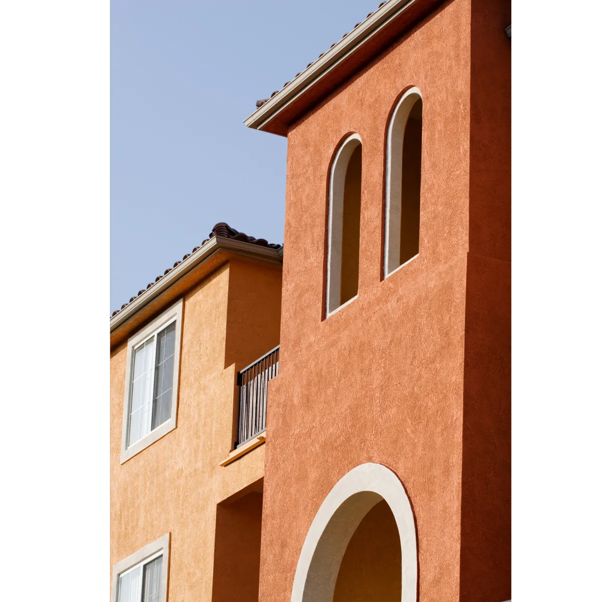 apartment complex with red and orange stucco exterior