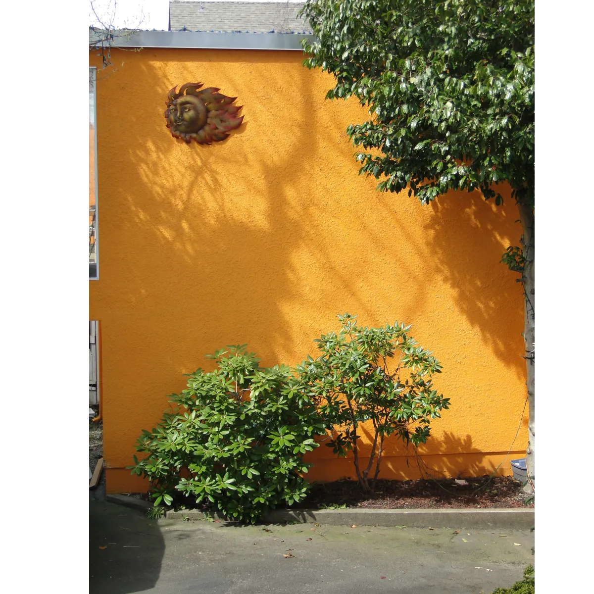 Orange stucco exterior on building with a sun statue