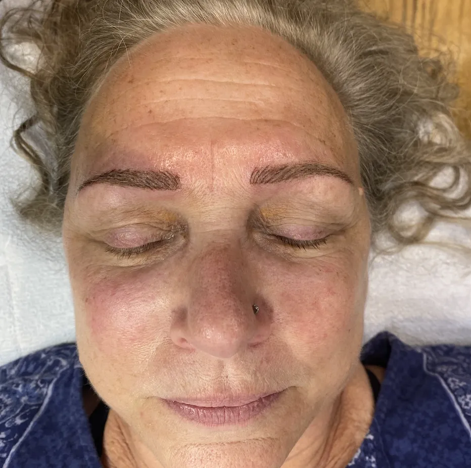 After tantric tattoo permanent makeup treatment showing defined brows and enhanced eyeliner results.