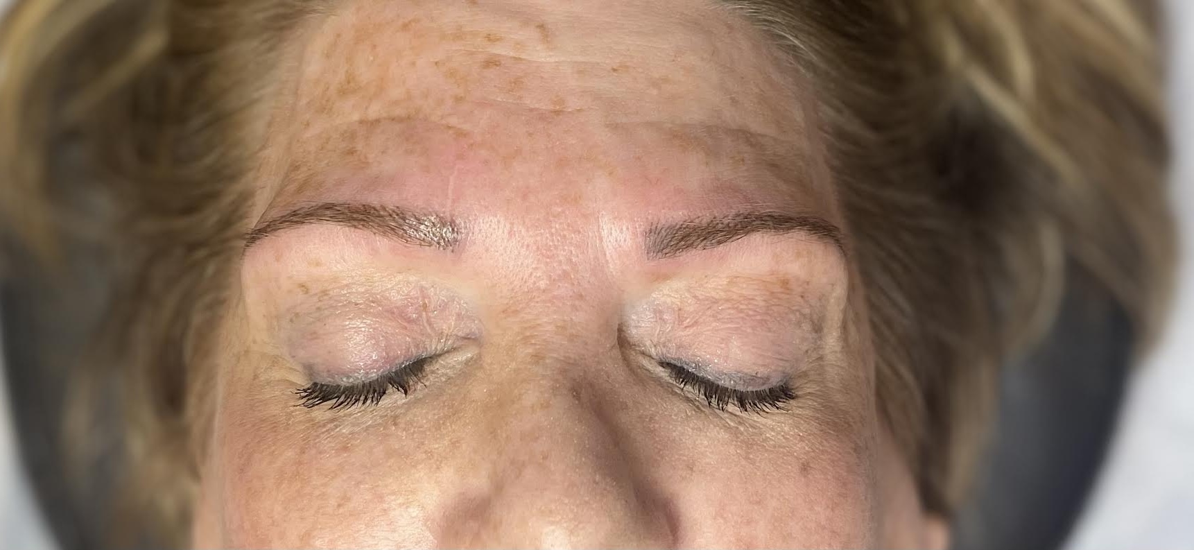 After tantric tattoo permanent makeup treatment showing defined brows and enhanced eyeliner results.