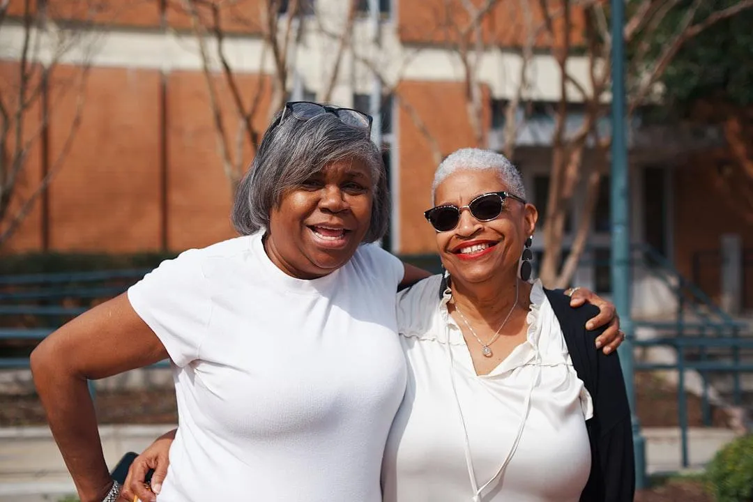 two african america women taking a picture side by side and holding each other