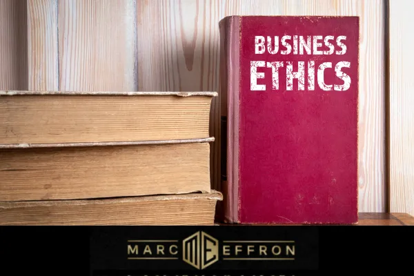 A stack of books with a red Business Ethics book standing up to the right. At the bottom is the Marc Effron logo.