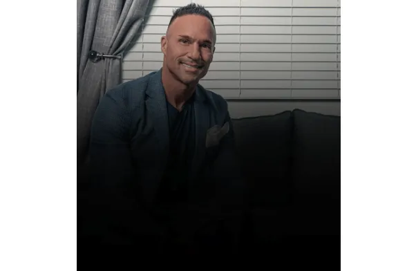 Marc Effron sitting on a coach and smiling at the camera.