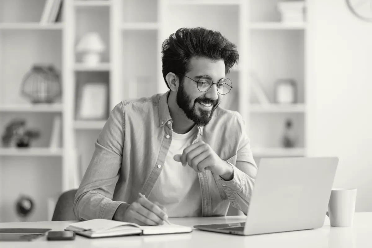 a happy smiling busines man in font of a laptop