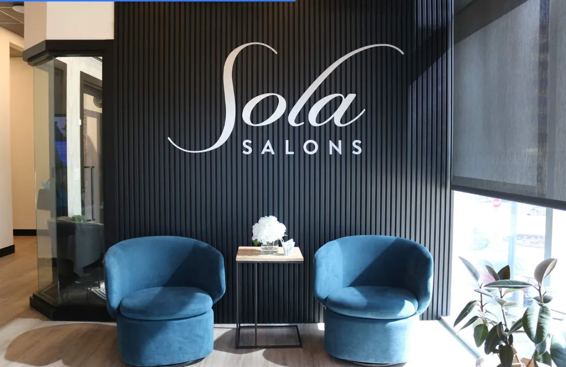 Two colleagues discussing documents at an office desk.